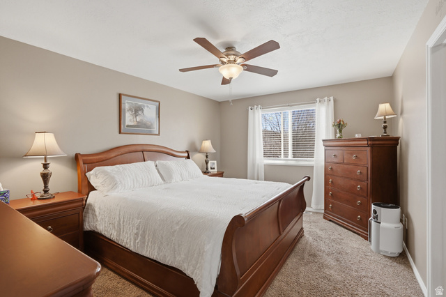 7737 Ranches Parkway Eagle Mountain, UT 84005 - Photo 10 of 28 Carpeted room with a window featuring blinds and white curtains, a ceiling fan with integrated lighting, and neutral wall tones