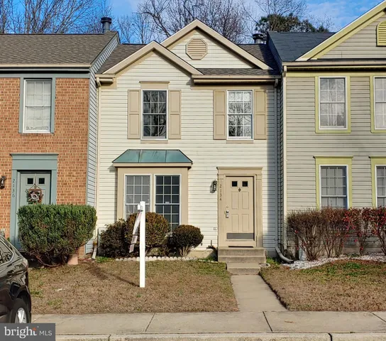 a view of a white house with large windows and a yard