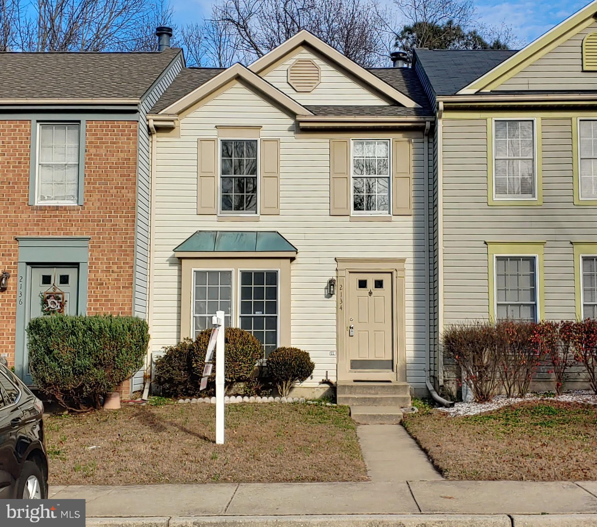 a view of a white house with large windows and a yard