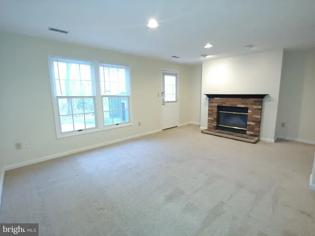 an empty room with fireplace and windows