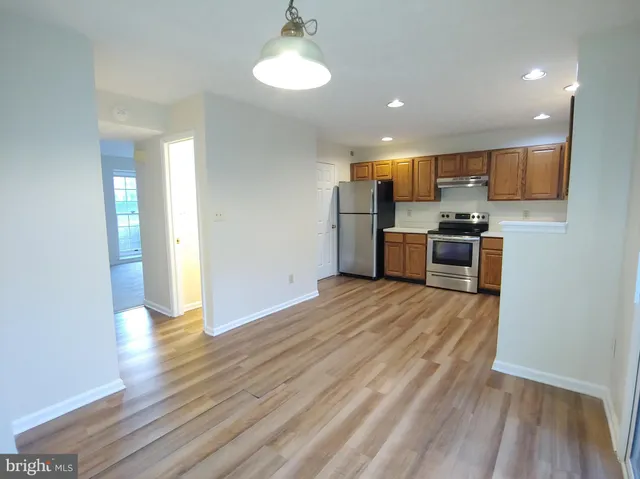 a view of kitchen appliances wooden floor and a window