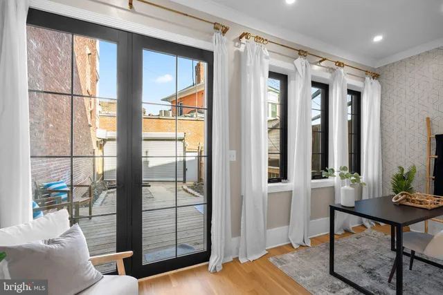 a bathroom with a toilet a sink a large mirror and a window