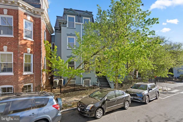 a bedroom with a large bed and wooden floor