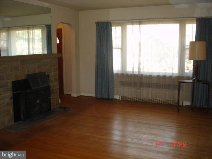7000 Warfield Road Gaithersburg, MD 20882 - Photo 6 of 12 an empty room with wooden floor fireplace and windows