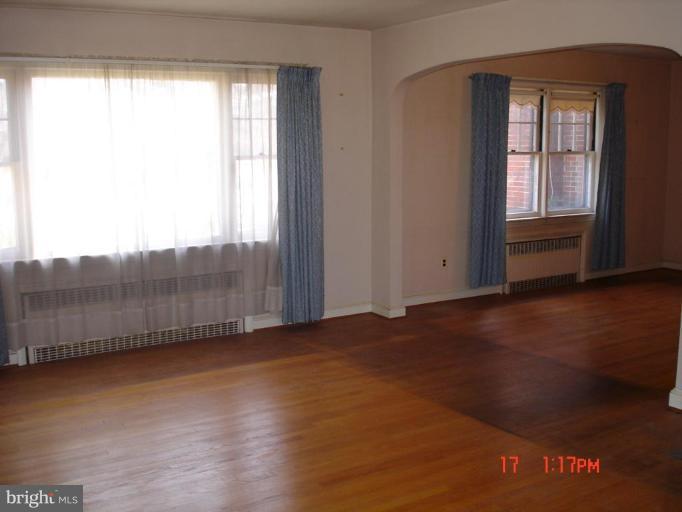 7000 Warfield Road Gaithersburg, MD 20882 - Photo 7 of 12 an empty room with wooden floor and windows