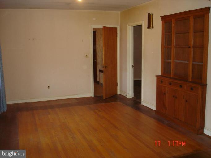 7000 Warfield Road Gaithersburg, MD 20882 - Photo 8 of 12 an empty room with wooden floor and cabinet