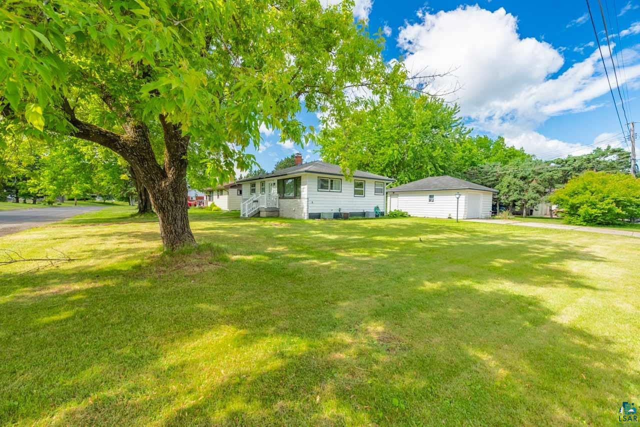 301 2nd Street North Biwabik, MN 55708 - Photo 31 of 43 Expansive front lawn with mature trees and a detached garage