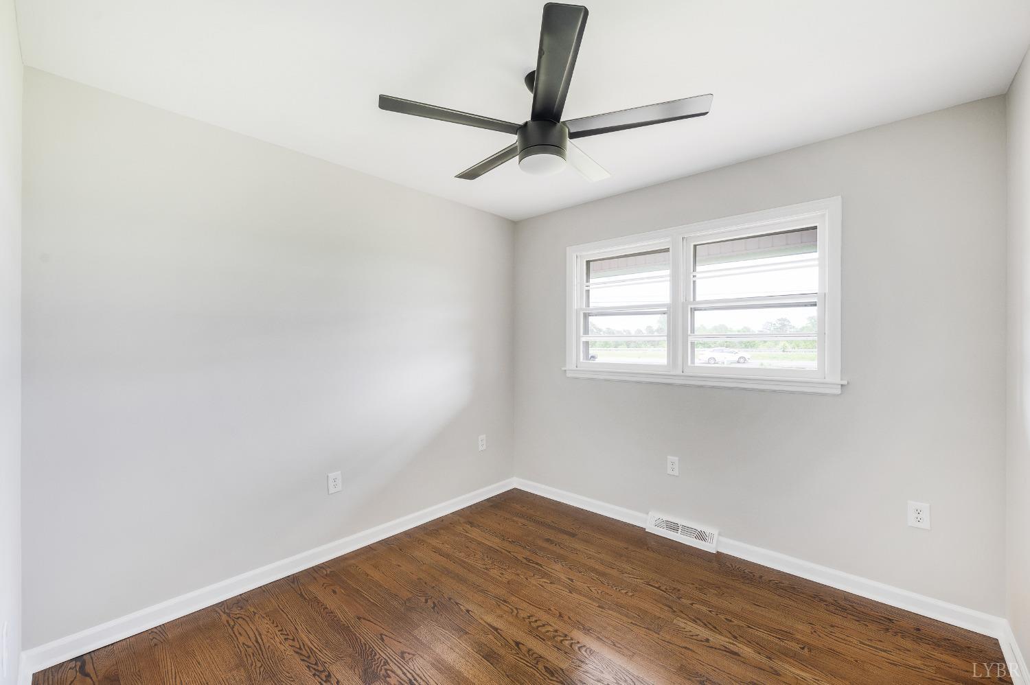 7230 Wards Road Rustburg, VA 24588 - Photo 36 of 58 an empty room with wooden floor fan and windows