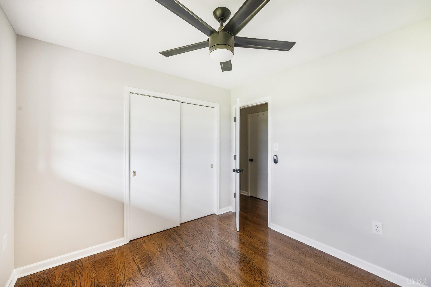 7230 Wards Road Rustburg, VA 24588 - Photo 37 of 58 an empty room with wooden floor and a ceiling fan