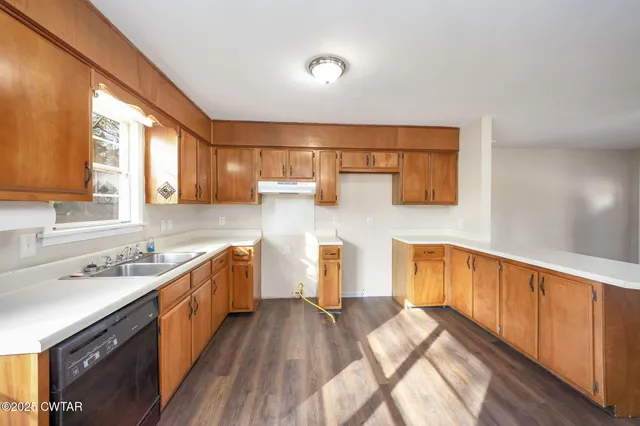 a kitchen with a sink and wooden floor