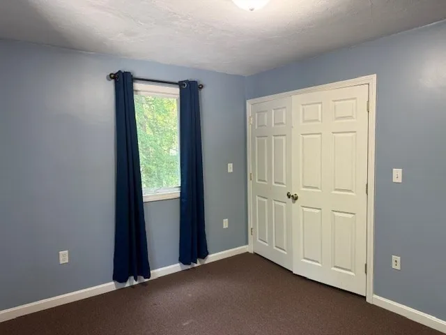 an empty room with windows and closet area