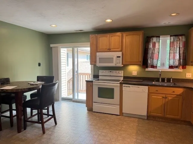 a kitchen with a stove a sink a microwave a dining table and chairs