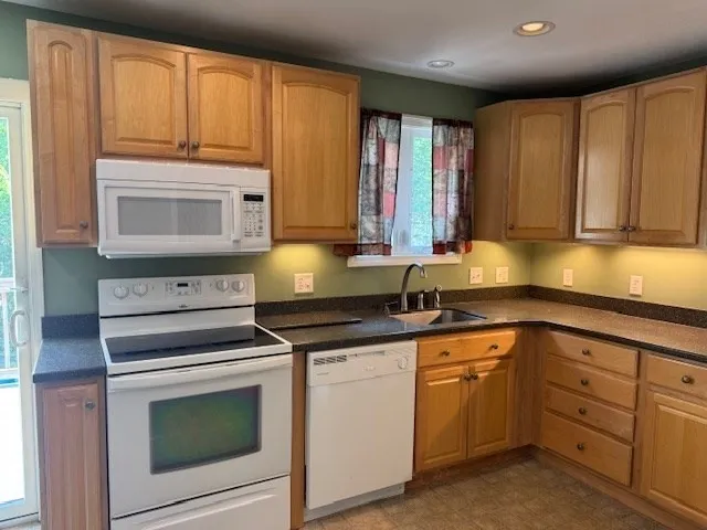 a kitchen with granite countertop cabinets stainless steel appliances and a sink
