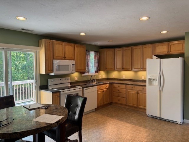 14 Moss Street, Unit 2 Burlington, MA 01803 - Photo 6 of 22 a kitchen with stainless steel appliances granite countertop a stove a refrigerator a sink dishwasher a dining table and chairs with wooden floor
