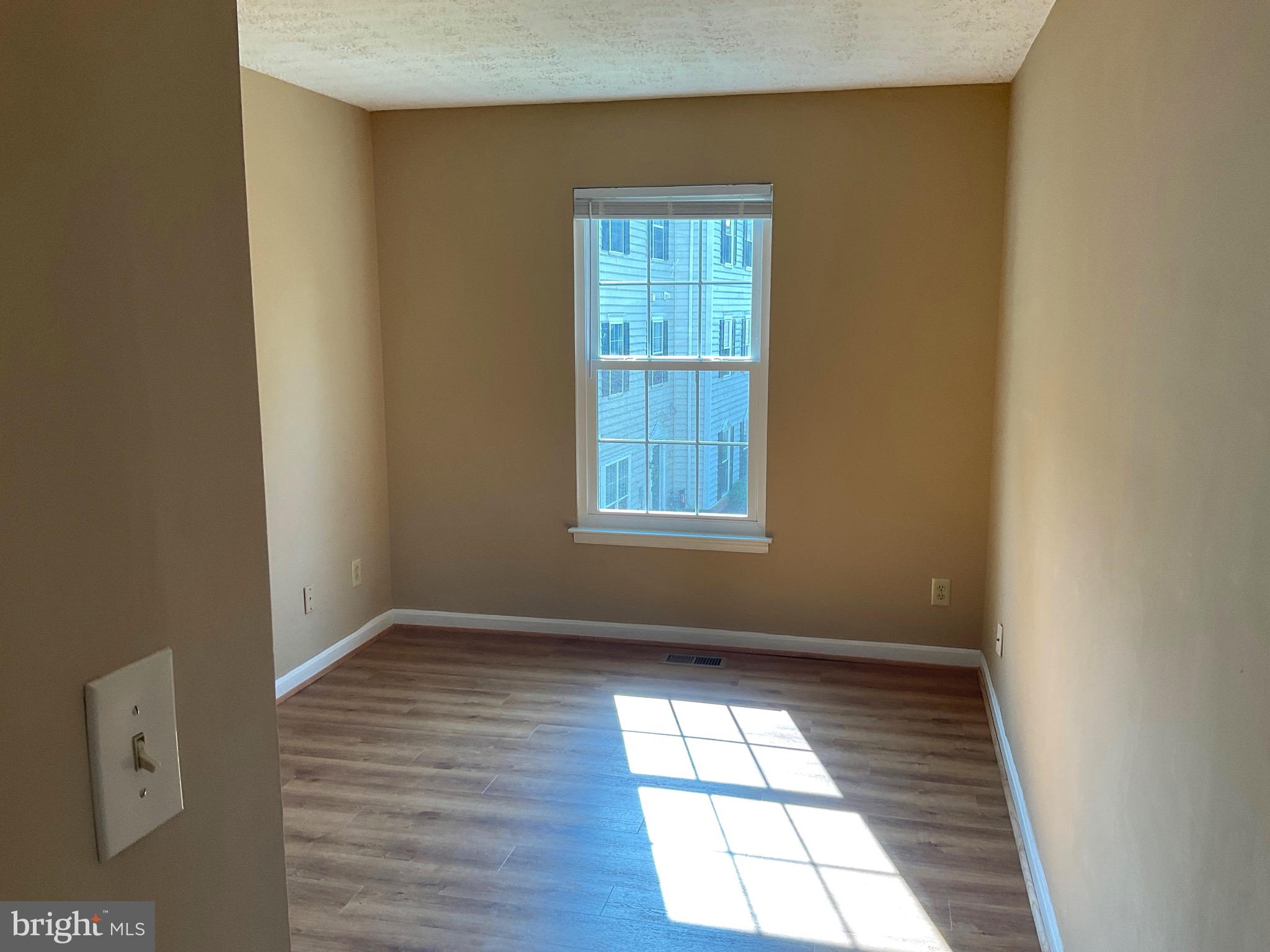 2152 Bristol Drive, Unit 4 Frederick, MD 21702 - Photo 6 of 12 an empty room with wooden floor and windows
