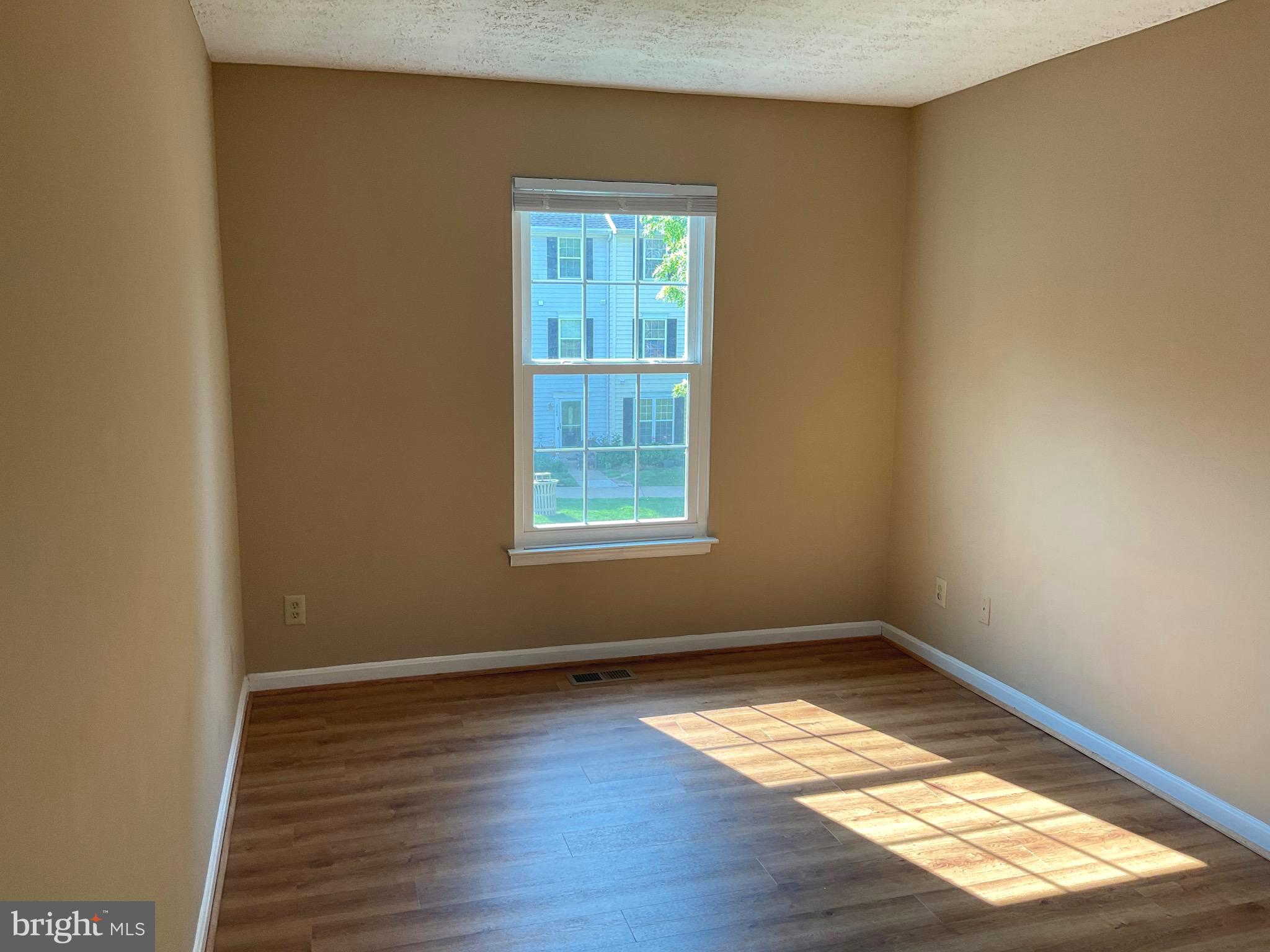 2152 Bristol Drive, Unit 4 Frederick, MD 21702 - Photo 7 of 12 an empty room with wooden floor and windows