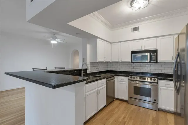 a kitchen with granite countertop a sink and stainless steel appliances