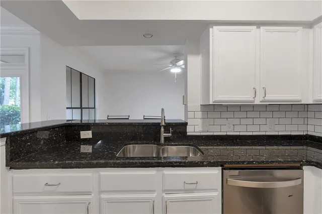 a kitchen with granite countertop a sink and cabinets