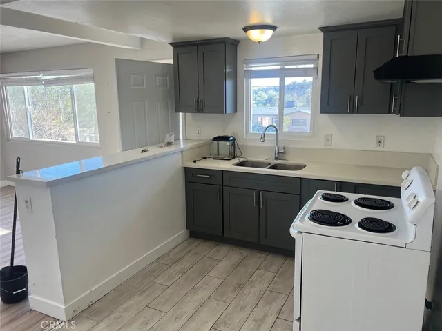a kitchen with a sink a stove and cabinets