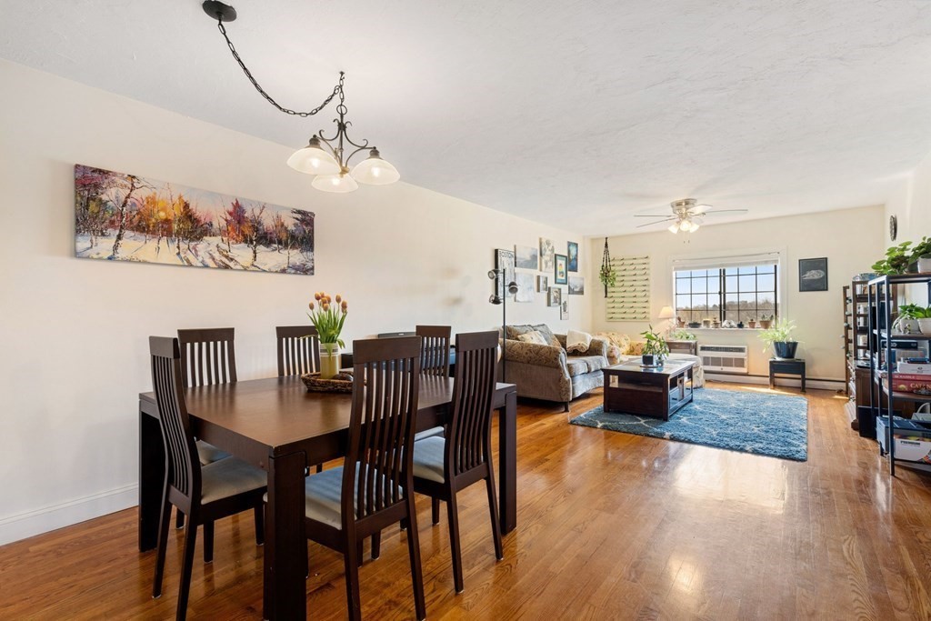 474 Broadway, Unit 49 Somerville, MA 02145 - Photo 2 of 19 a view of a dining room and livingroom with furniture wooden floor a rug and a chandelier