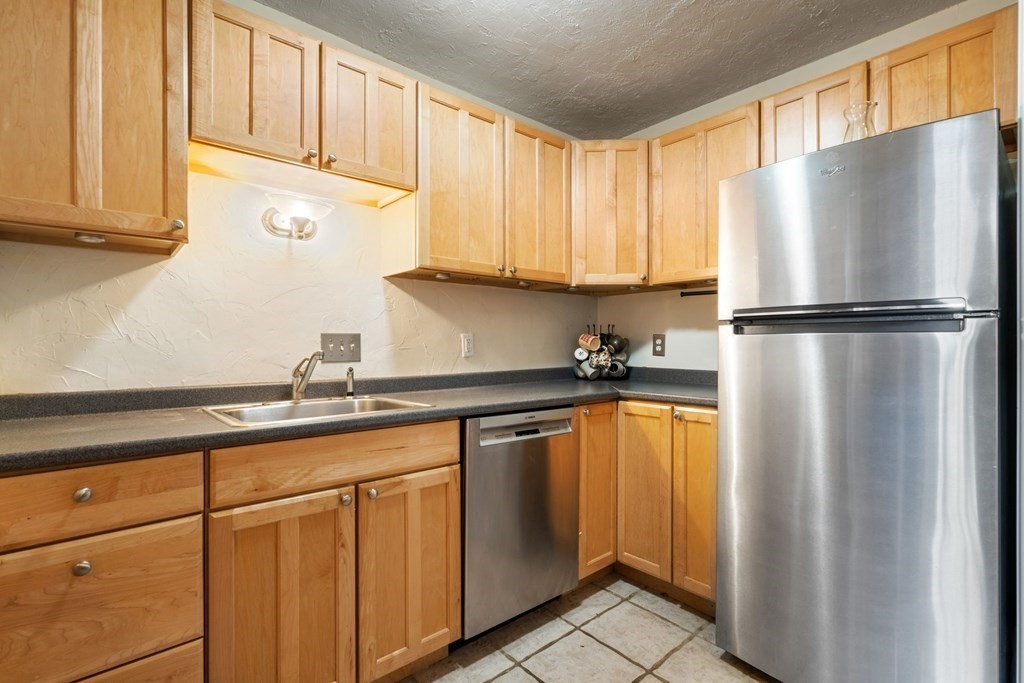 474 Broadway, Unit 49 Somerville, MA 02145 - Photo 6 of 19 a white refrigerator freezer sitting in a kitchen