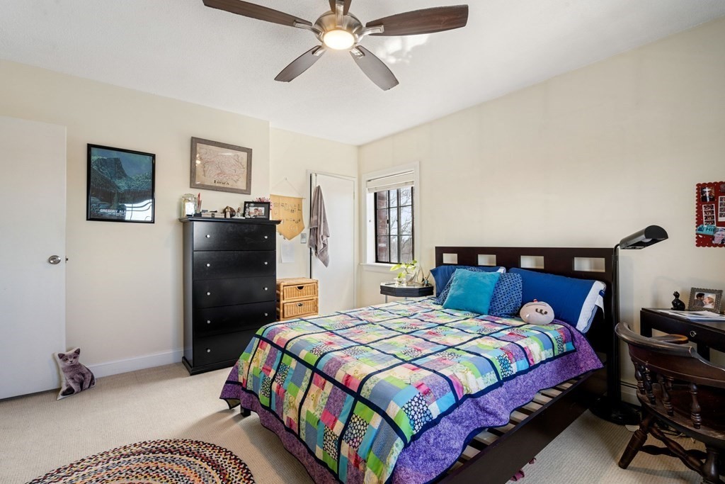 474 Broadway, Unit 49 Somerville, MA 02145 - Photo 10 of 19 a bedroom with a bed and a chandelier