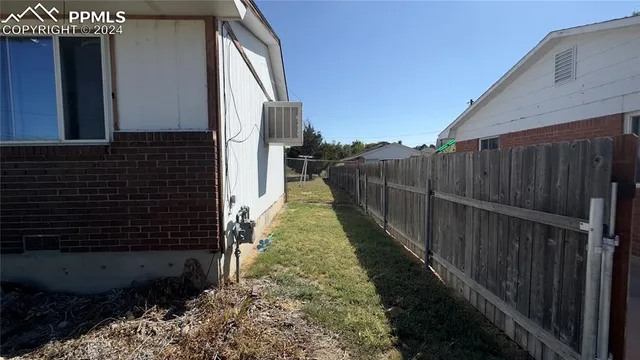 a view of a pathway of a house with wooden fence
