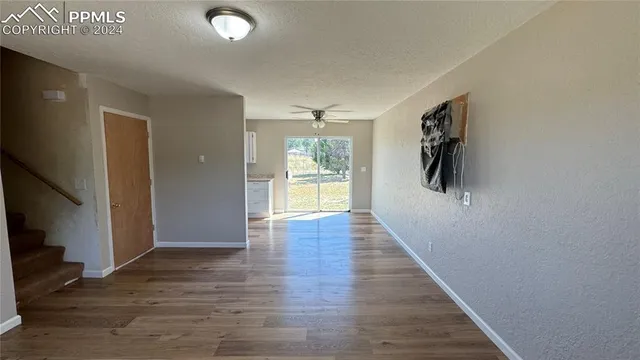 a view of a hallway with wooden floor and windows