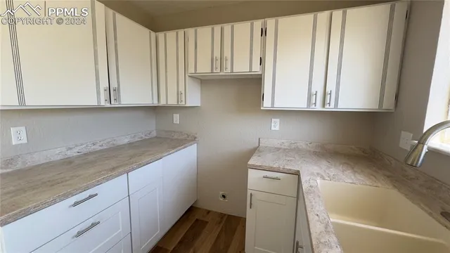 a kitchen with a sink cabinets and a window