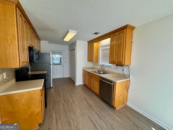 a kitchen with stainless steel appliances granite countertop a sink a stove and a refrigerator
