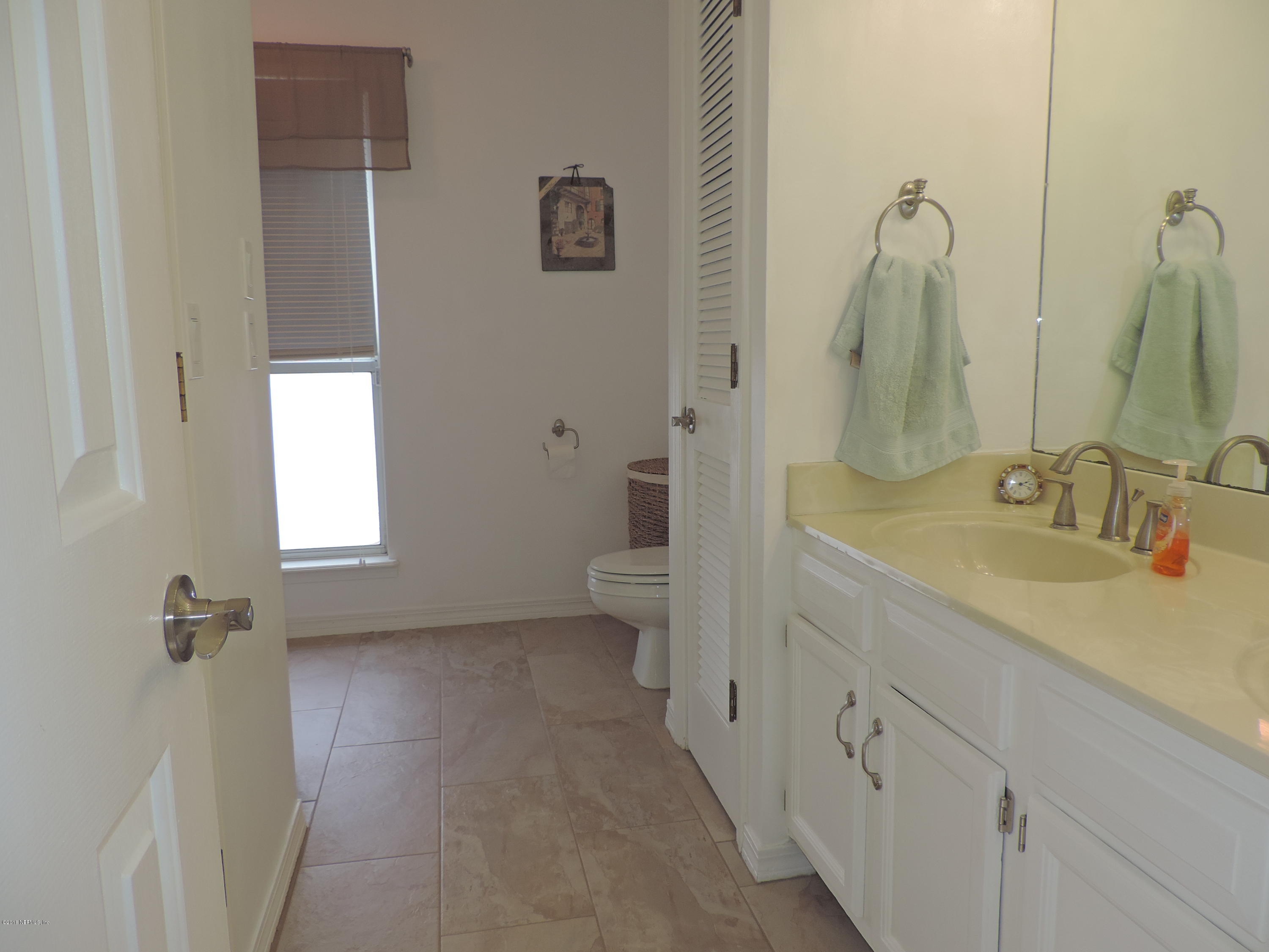 7024 St Augustine Road Jacksonville, FL 32217 - Photo 19 of 34 a spacious bathroom with a double vanity sink toilet and a mirror