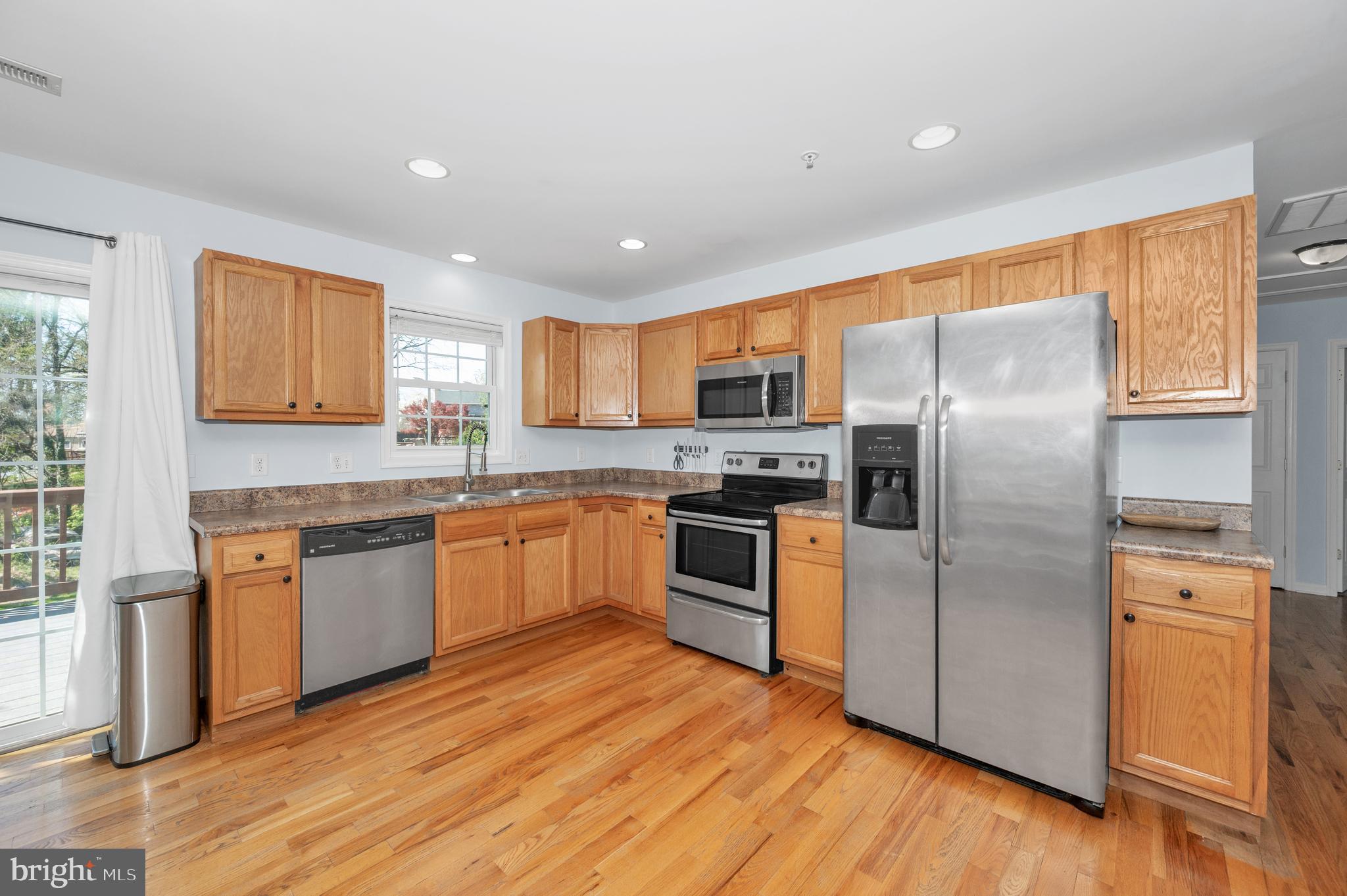 1107 2nd Avenue Brunswick, MD 21716 - Photo 12 of 52 a kitchen with granite countertop stainless steel appliances a refrigerator cabinets and wooden floor