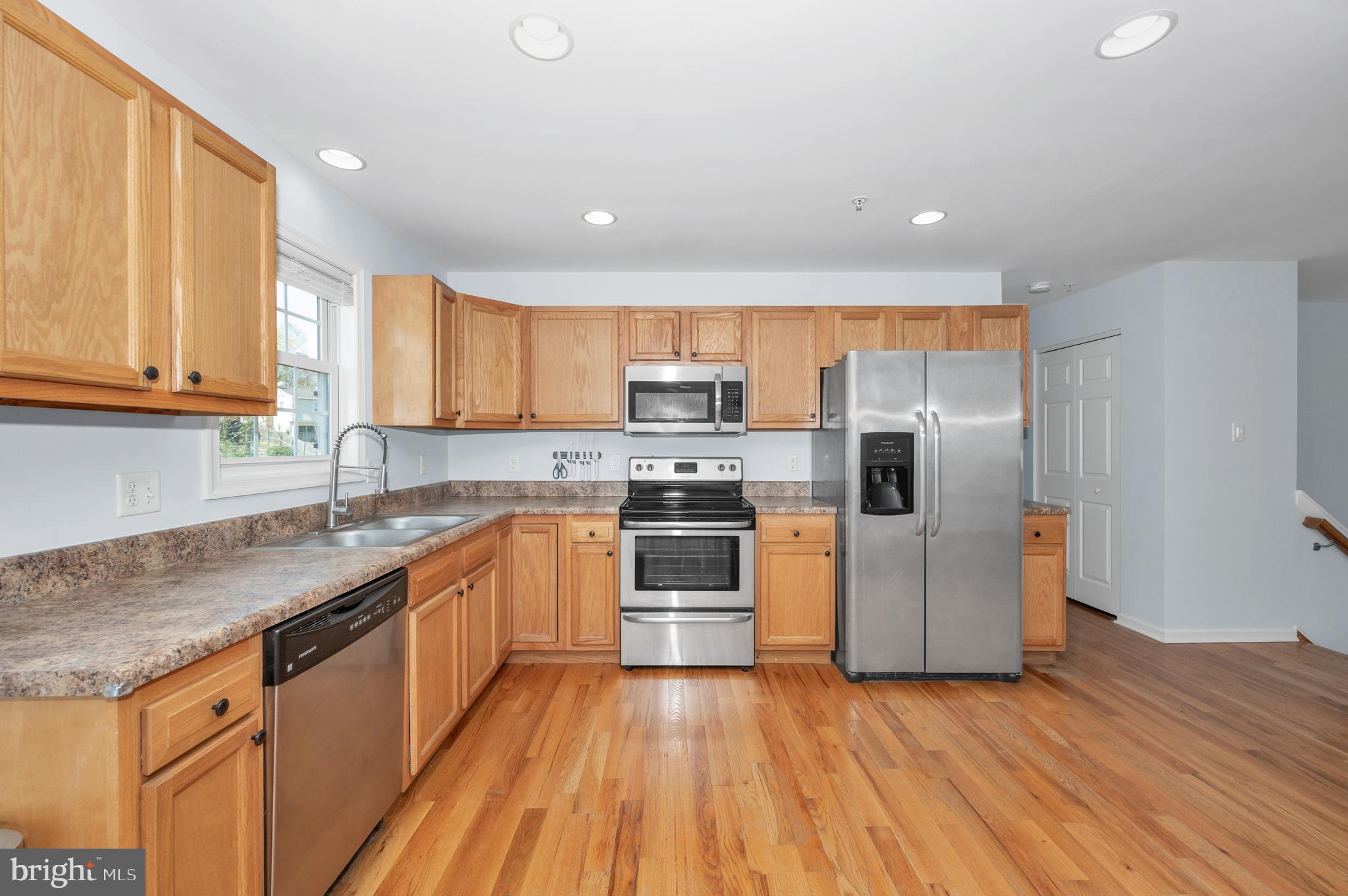 1107 2nd Avenue Brunswick, MD 21716 - Photo 13 of 52 a kitchen with stainless steel appliances granite countertop a refrigerator a sink dishwasher a stove with wooden cabinets and floors