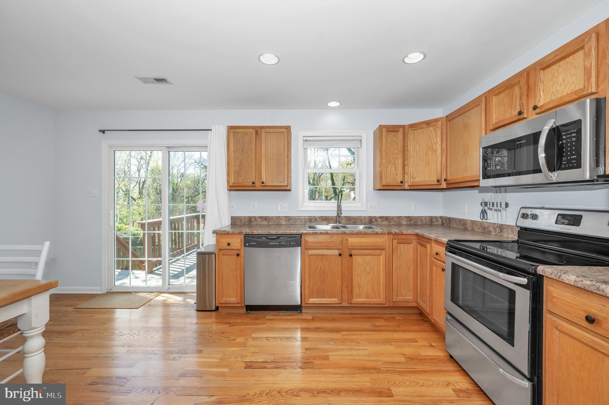 1107 2nd Avenue Brunswick, MD 21716 - Photo 15 of 52 a kitchen with stainless steel appliances granite countertop wooden cabinets a stove a sink and dishwasher next to a window