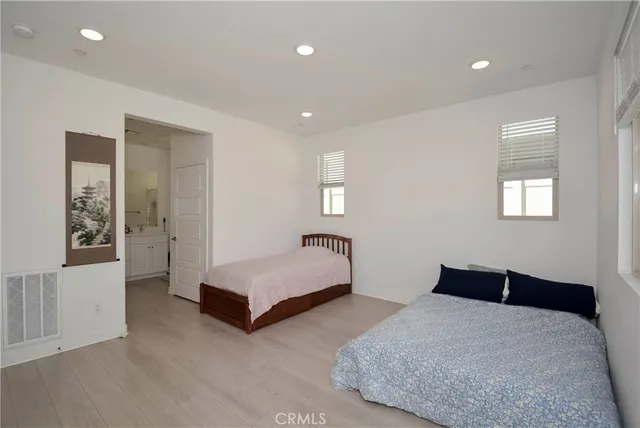 a spacious bedroom with a bed and cabinet