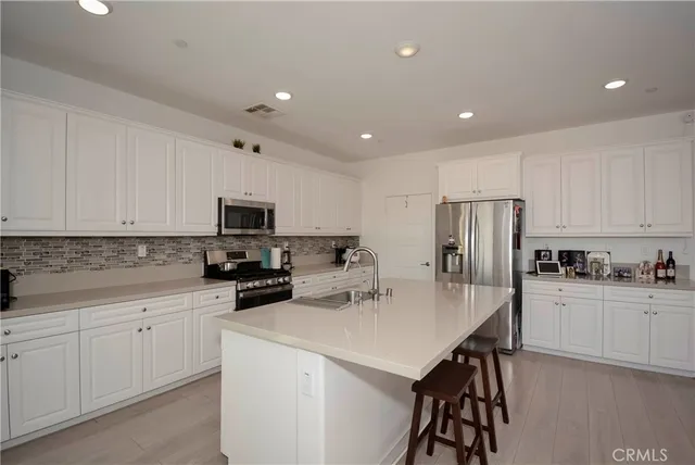 a kitchen with white cabinets and stainless steel appliances