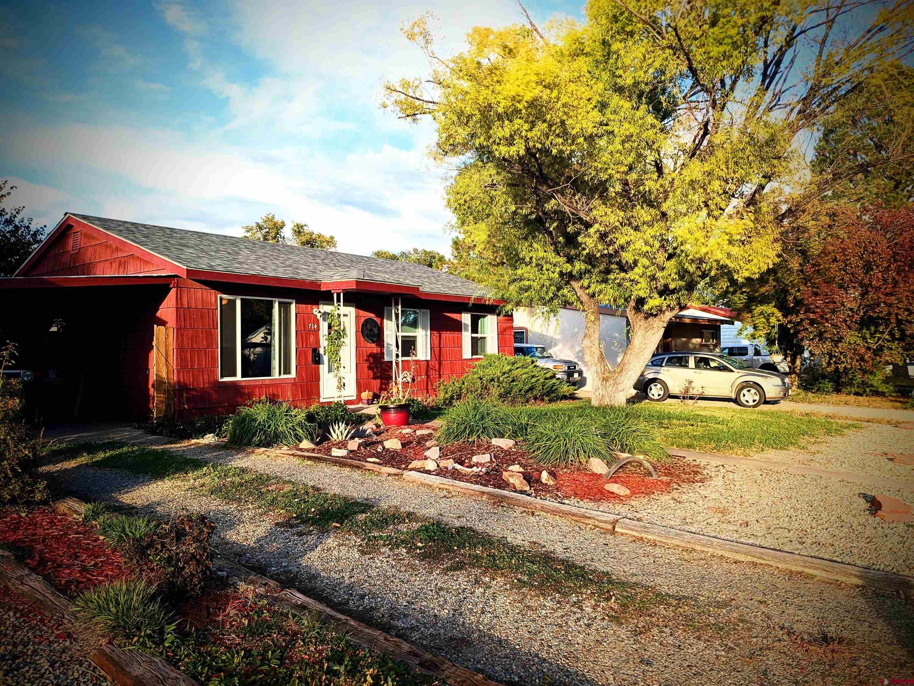 a front view of house with yard and trees around
