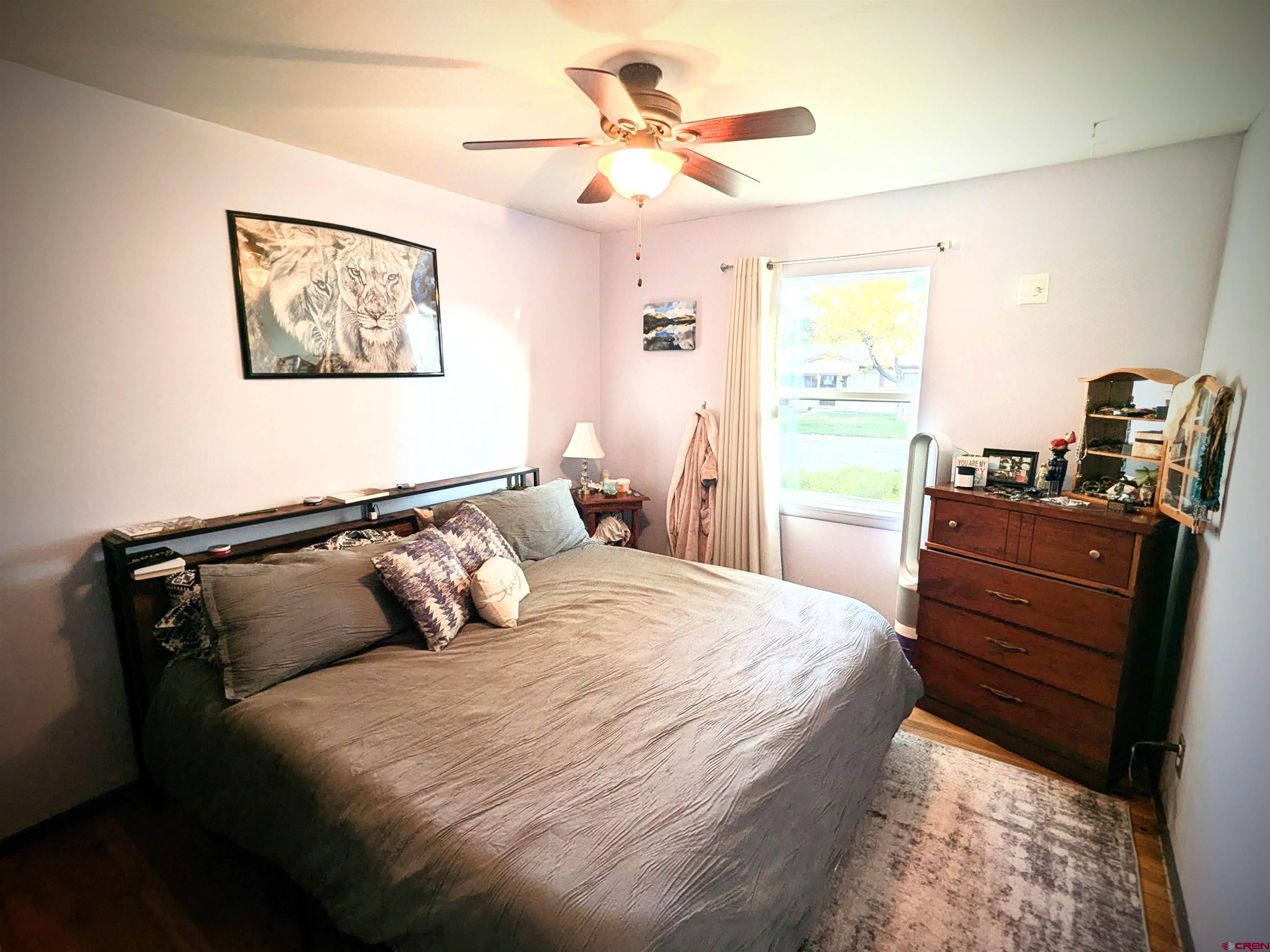 714 East 3rd Street Cortez, CO 81321 - Photo 11 of 14 a bedroom with a bed and wooden floor