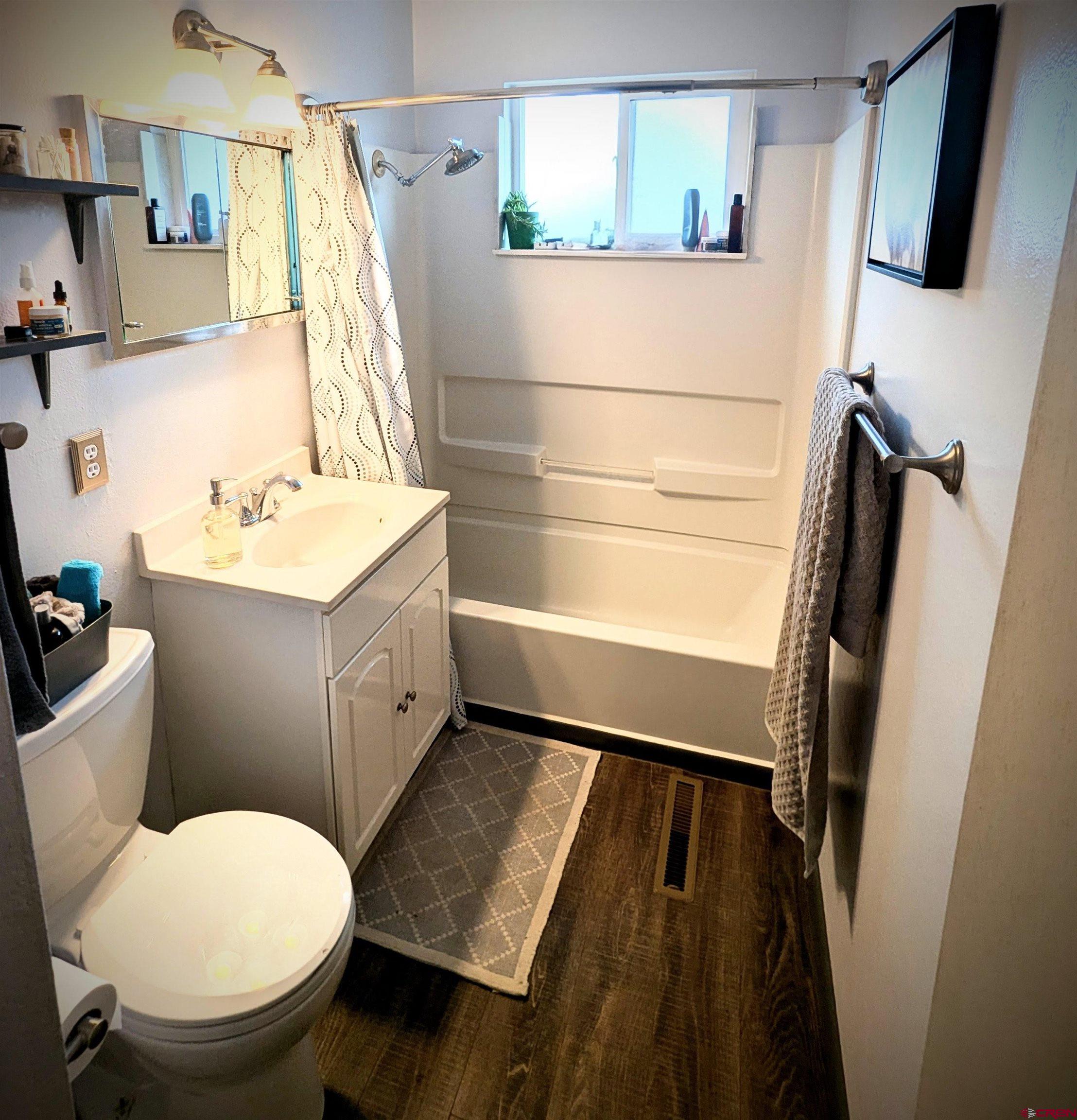 714 East 3rd Street Cortez, CO 81321 - Photo 12 of 14 a bathroom with a sink a toilet and a mirror