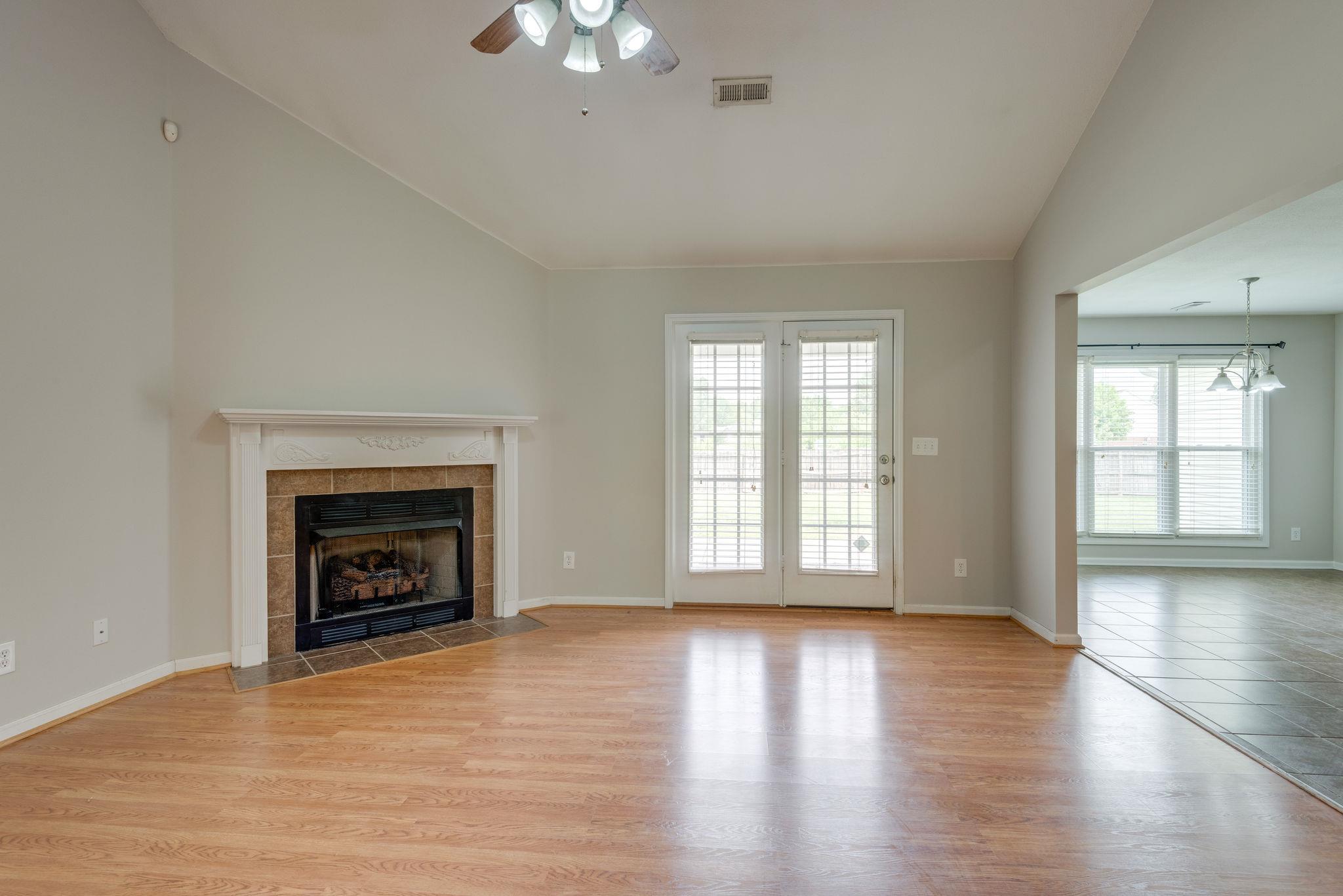 3753 Trough Springs Road Adams, TN 37010 - Photo 7 of 28 an empty room with wooden floor fireplace and windows