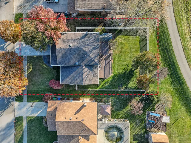 an aerial view of a house with a yard and a large pool
