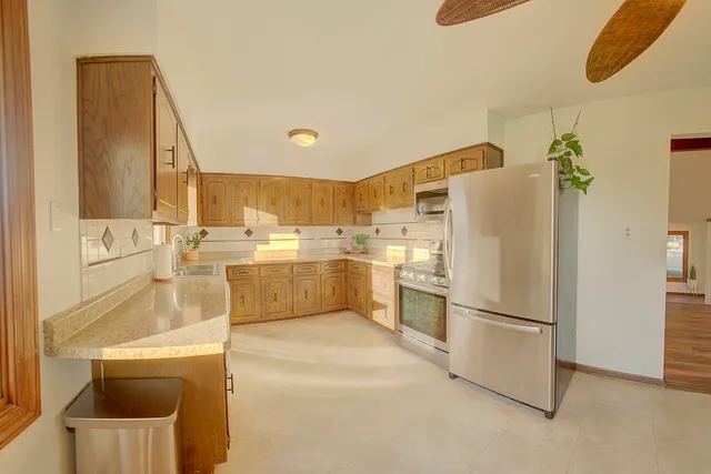a kitchen with a refrigerator a sink and cabinets