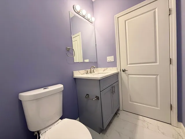 a bathroom with a toilet sink vanity and mirror