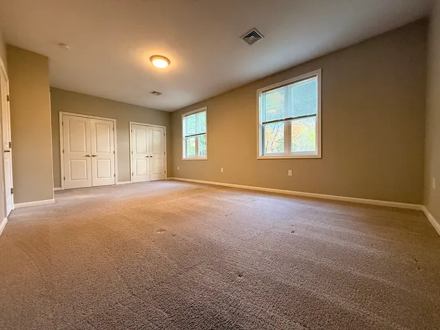 an empty room with windows and closet