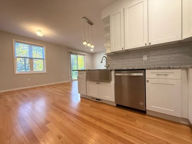 an empty room with wooden floor and cabinet