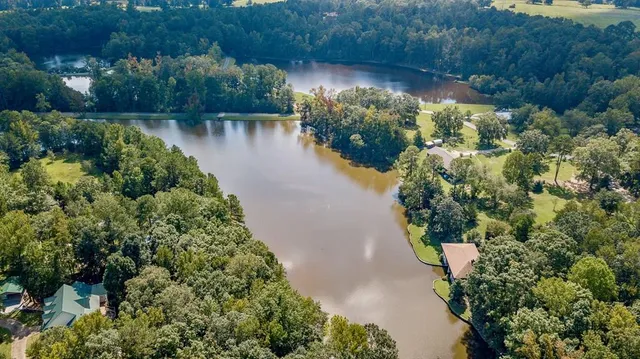 an aerial view of a house with a yard and lake view