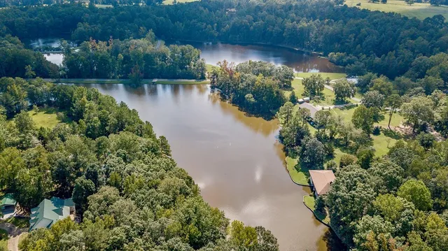 an aerial view of a house with a yard and lake view