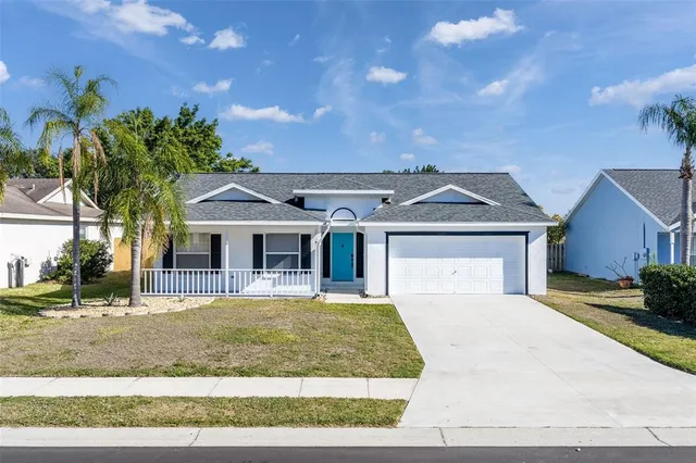 a view of a white house with a big yard and large trees