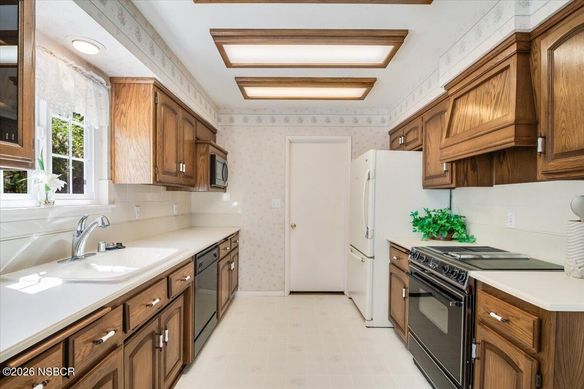 416 South Hawthorne Street Lompoc, CA 93436 - Photo 7 of 29 a kitchen with stainless steel appliances granite countertop a sink and a stove