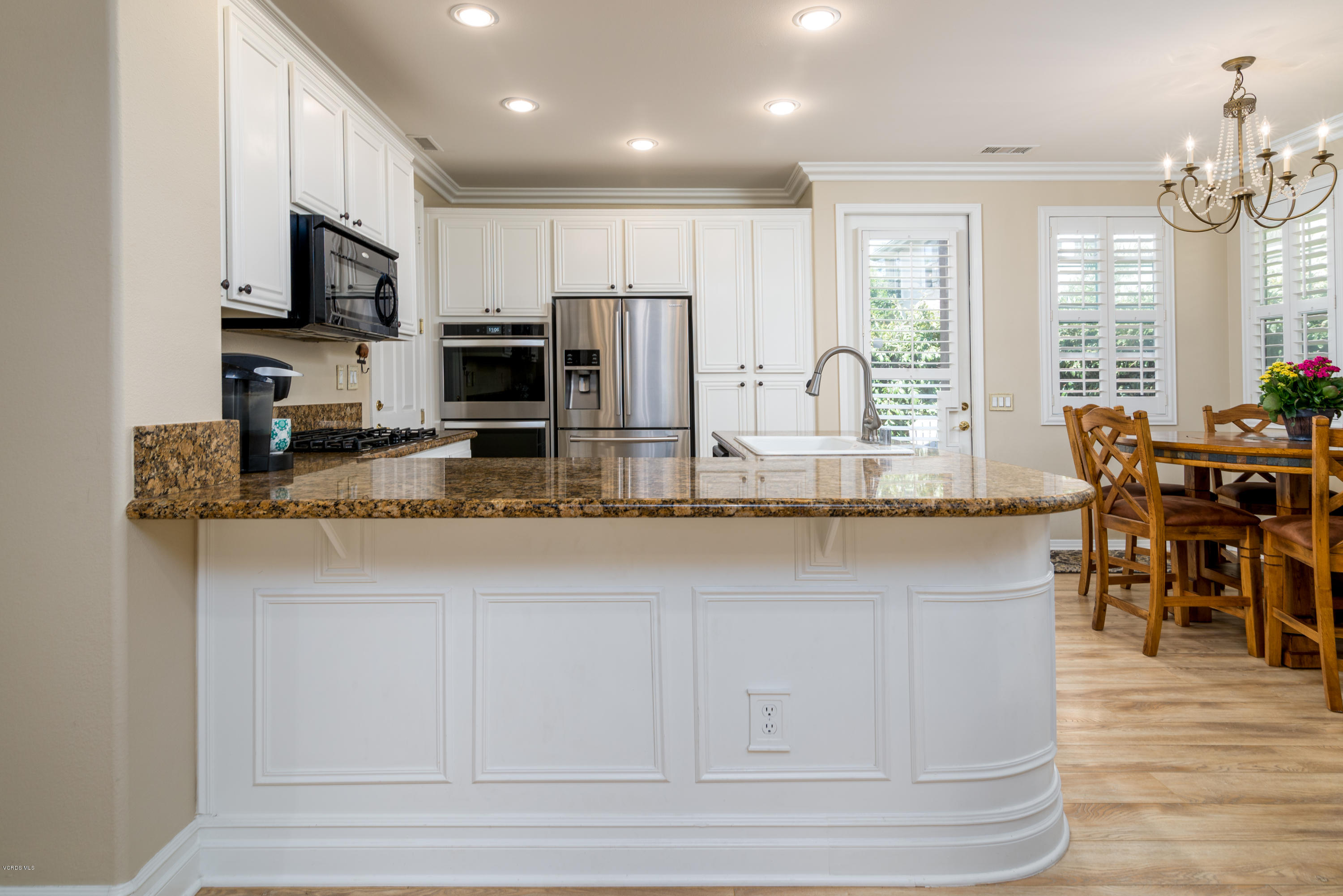 421 Spring Park Road Camarillo, CA 93012 - Photo 10 of 51 a kitchen with stainless steel appliances granite countertop a stove a sink a refrigerator a dining table and chairs with wooden floor